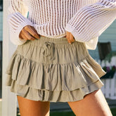 Person wearing a white crochet top and beige ruffled skirt